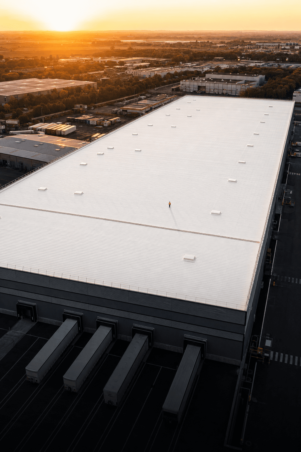 Vue aérienne d'un entrepôt logistique français avec toiture cool roof blanche réfléchissante